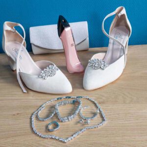 Bruidsaccessoires met witte bruidsschoenen, pareltasje en sieraden inclusief ketting, armband en oorbellen.