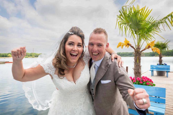 Bruidspaar Pim en Gladys juichen van geluk op de steiger bij Paviljoen het Buitenhuis, Ewijk.