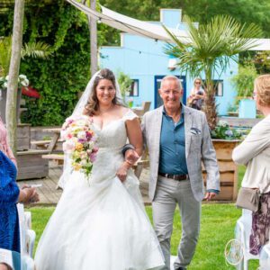 Bruid Gladys en haar vader lopen de ceremonie binnen, bruidsfotografie door Arthur van Leeuwen.
