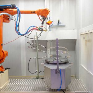Een close-up van een oranje ABB industriële robotarm in een schone, witte cel, mogelijk voor spuitwerk of oppervlaktebehandeling (FST) in Duiven.