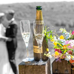 champagne met glazen, trouwringen , bruidspaar achtergrond