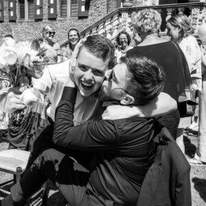 lachende mannen, innig omhelzen, vrolijke bruiloft